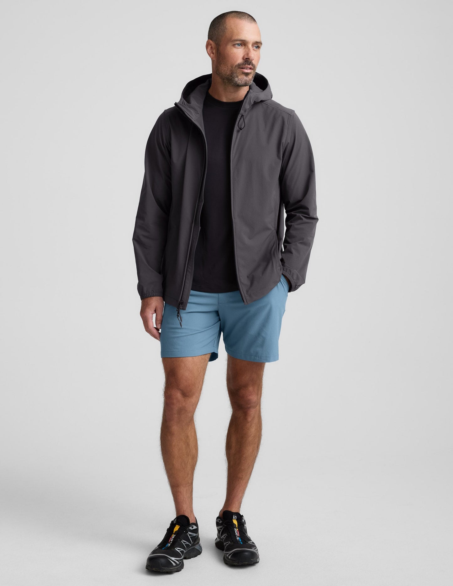 Pivotal 2.0 Men's Lined Short 7" in ice blue, worn by a model with a grey hooded jacket and black athletic sneakers.
