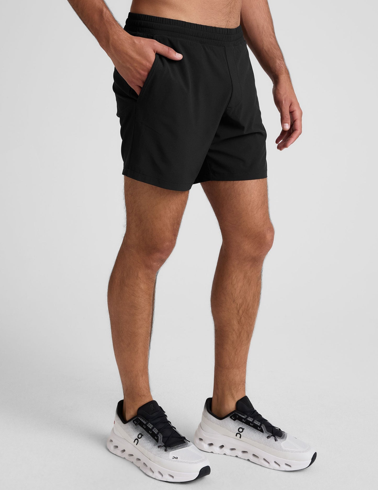 Side view of black Pivotal 2.0 Men's Lined Short 7" on a man, featuring a relaxed fit, elastic waist, and side pocket.