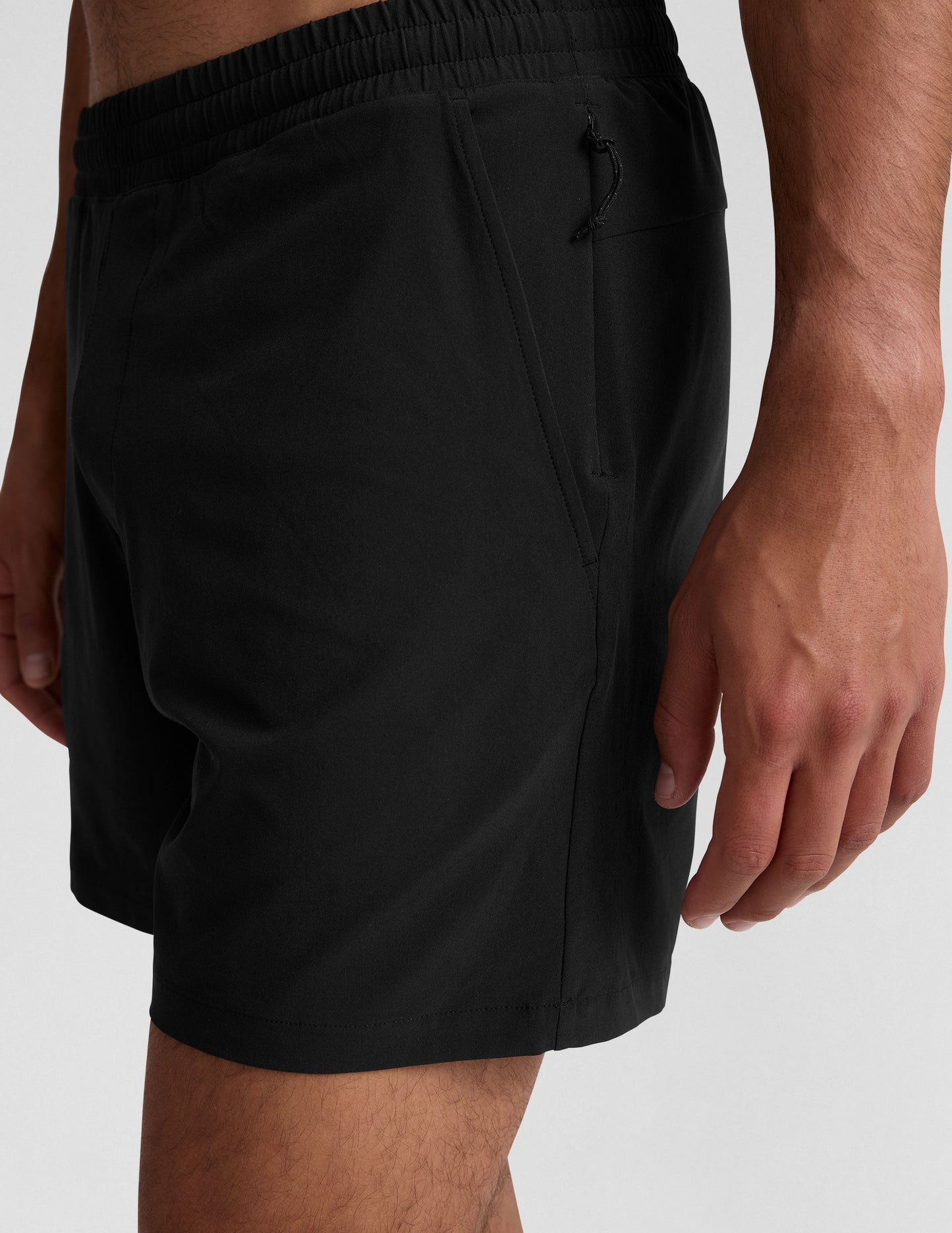 Side view of black Pivotal 2.0 Men's Lined Short 7" showing the elastic waistband and side pocket on a model.