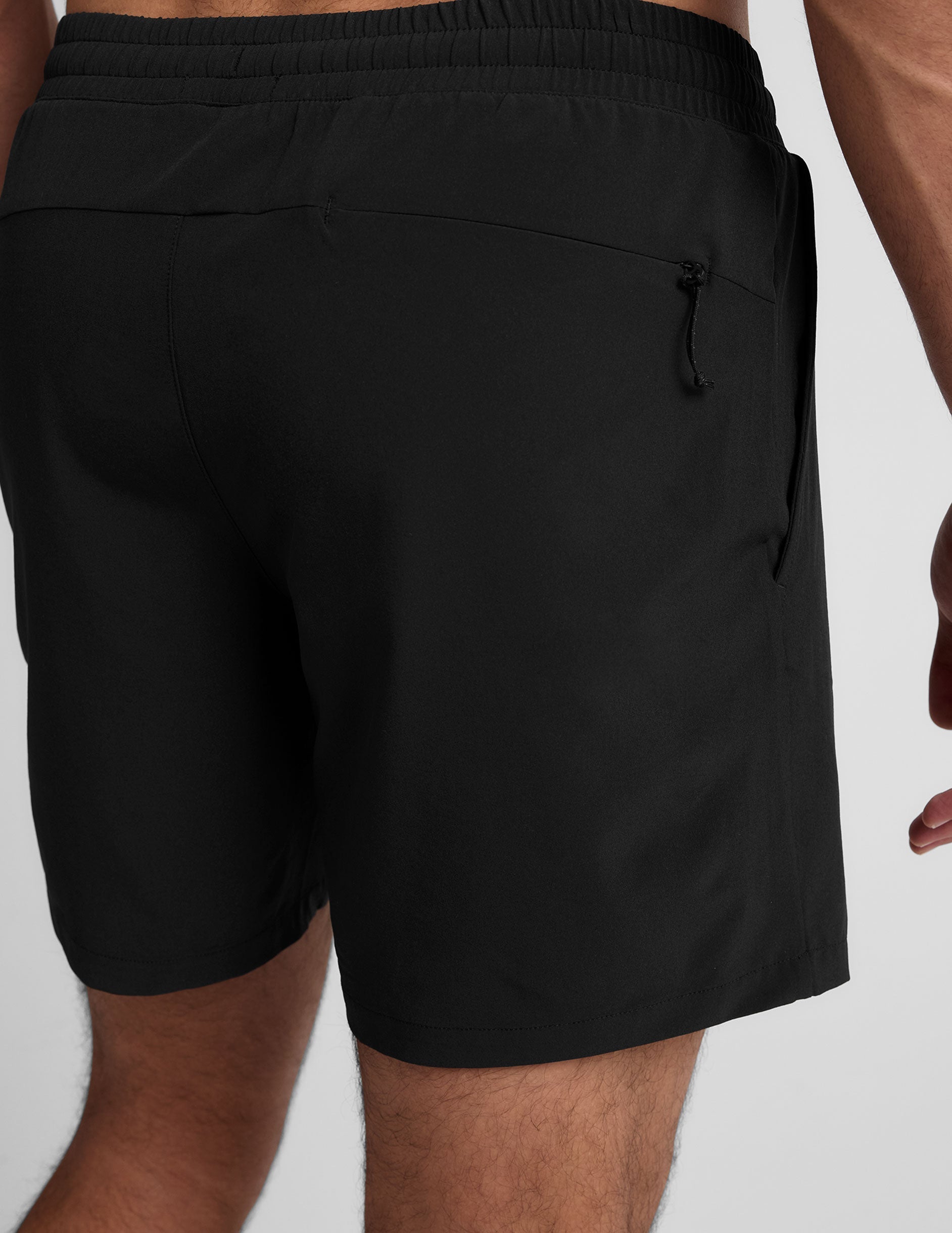 Back view of a man wearing black Pivotal 2.0 Lined Shorts featuring an elastic waistband and a back yoke zipper pocket.