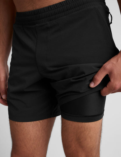 Black Pivotal 2.0 Men's Lined Short 7" showing the elastic waistband and a hand lifting the hem to reveal the inner liner.