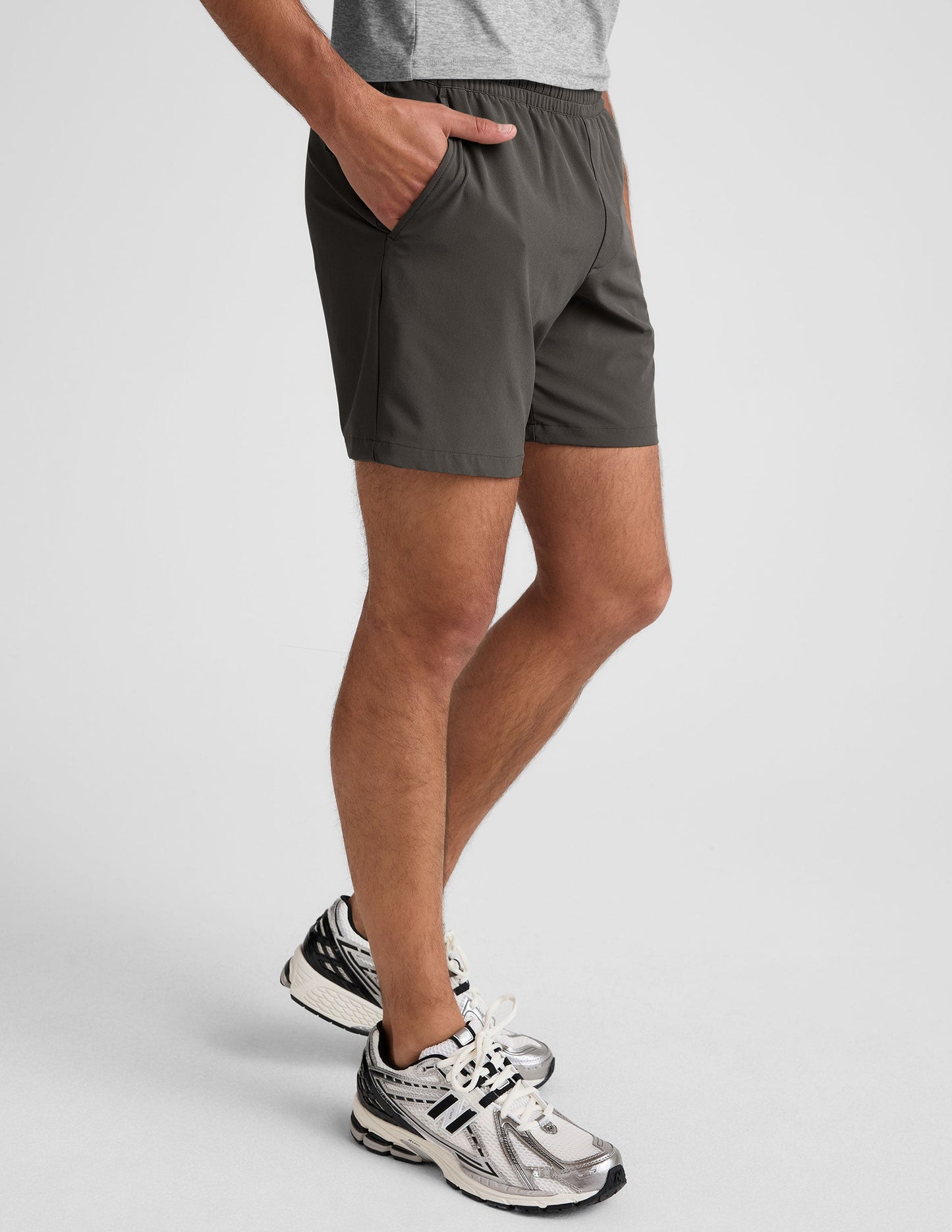 Side view of Pivotal 2.0 Men's Short 7" in dark gray, featuring an elastic waistband and side pockets on a relaxed fit.