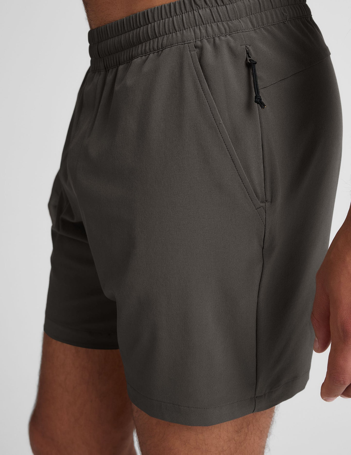 Side view of Pivotal 2.0 Men's Short in dark gray featuring an elastic waistband, side pocket, and a hidden zipper pocket.