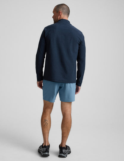 Rear view of man wearing Navy Pivotal™ 2.0 Men's Short 7" paired with a navy long-sleeve shirt and black sneakers.