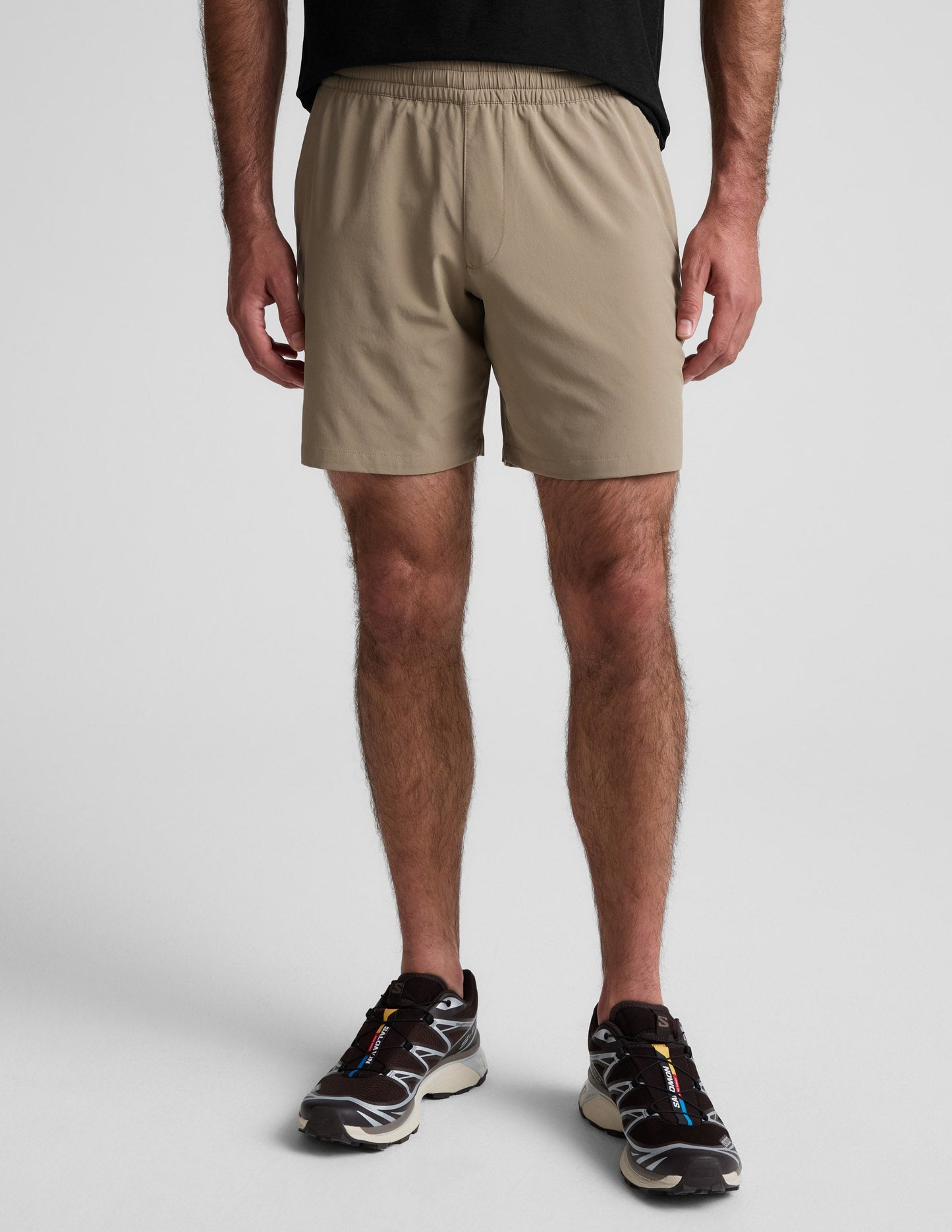 Front view of the beige Pivotal 2.0 Men's Short 7" featuring a gathered elastic waistband and relaxed mid-thigh fit.