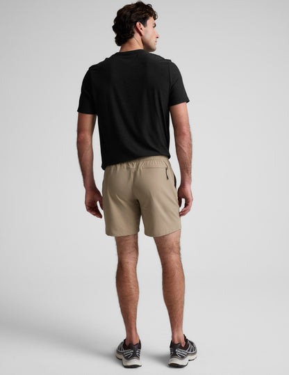 Rear view of beige Pivotal 2.0 Men's Short 7" featuring a gathered elastic waistband and back zipper pocket.