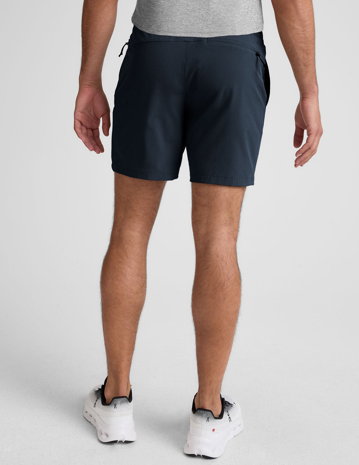 Rear view of a man wearing Pivotal 2.0 Men's Short 7" in navy with an elastic waistband and back zipper pocket.