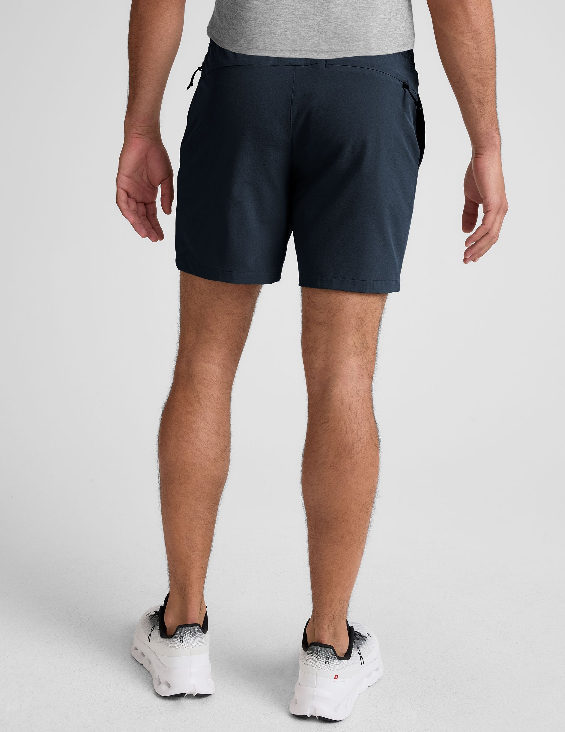 Rear view of a man wearing Pivotal 2.0 Men's Short 7" in navy with an elastic waistband and back zipper pocket.
