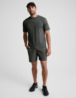 Man wearing Olive Pivotal 2.0™ Men's Short 7" paired with a matching short-sleeve t-shirt and black sneakers.