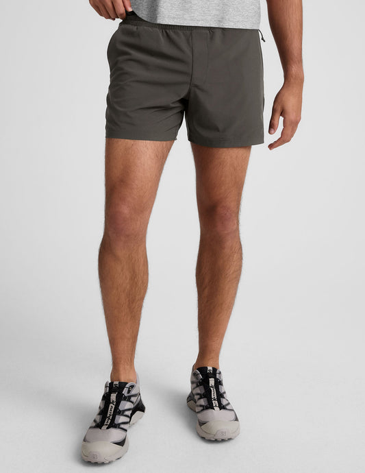 Front view of a man wearing the dark gray Pivotal 2.0 Men's Lined Short 5" with an elastic waistband and relaxed fit.