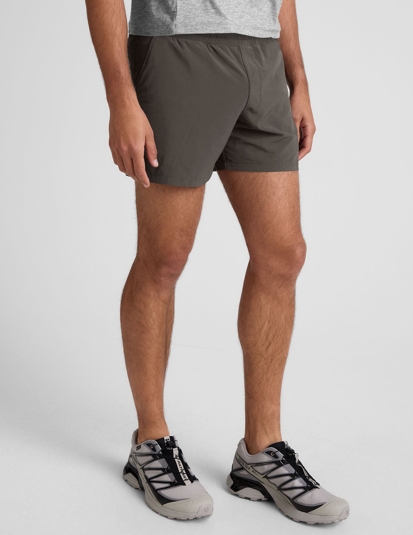 Pivotal 2.0 Men's Lined Short 5" in dark gray, featuring an elastic waistband and relaxed fit on a standing male model.