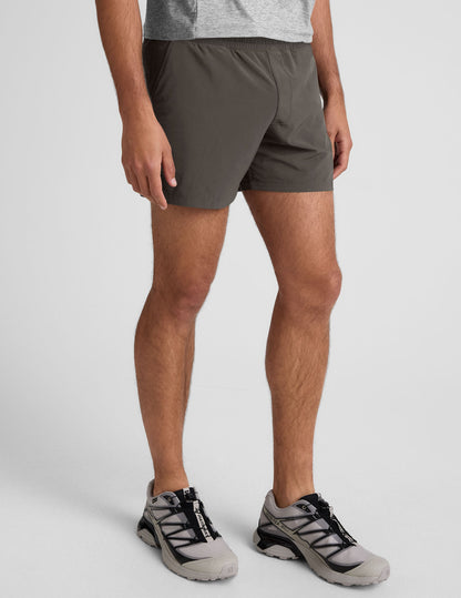 Pivotal 2.0 Men's Lined Short 5" in dark gray, featuring an elastic waistband and relaxed fit on a standing male model.