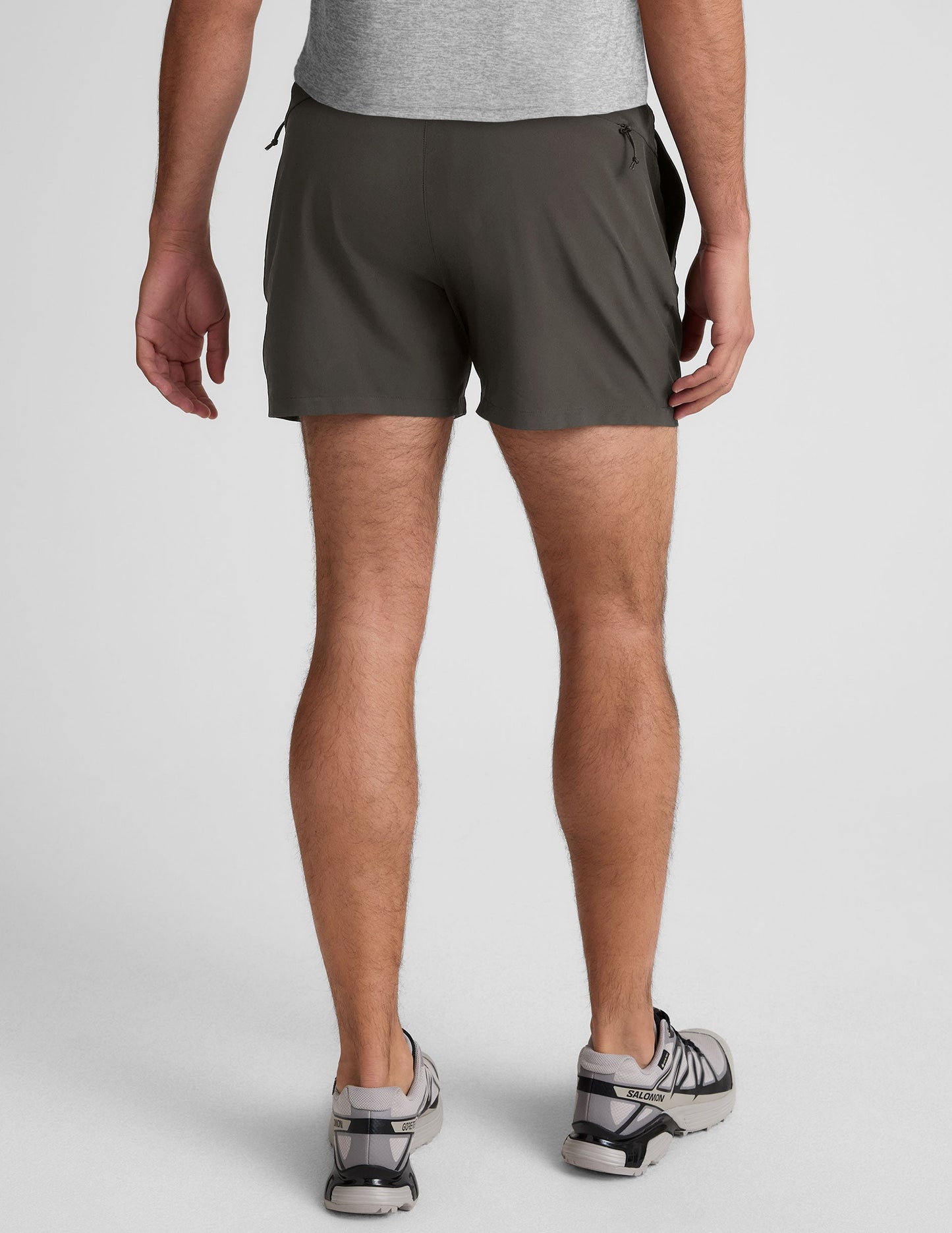 Back view of dark gray Pivotal 2.0 Men's Lined Short 5" on a model, showing the elastic waistband and mid-thigh length.