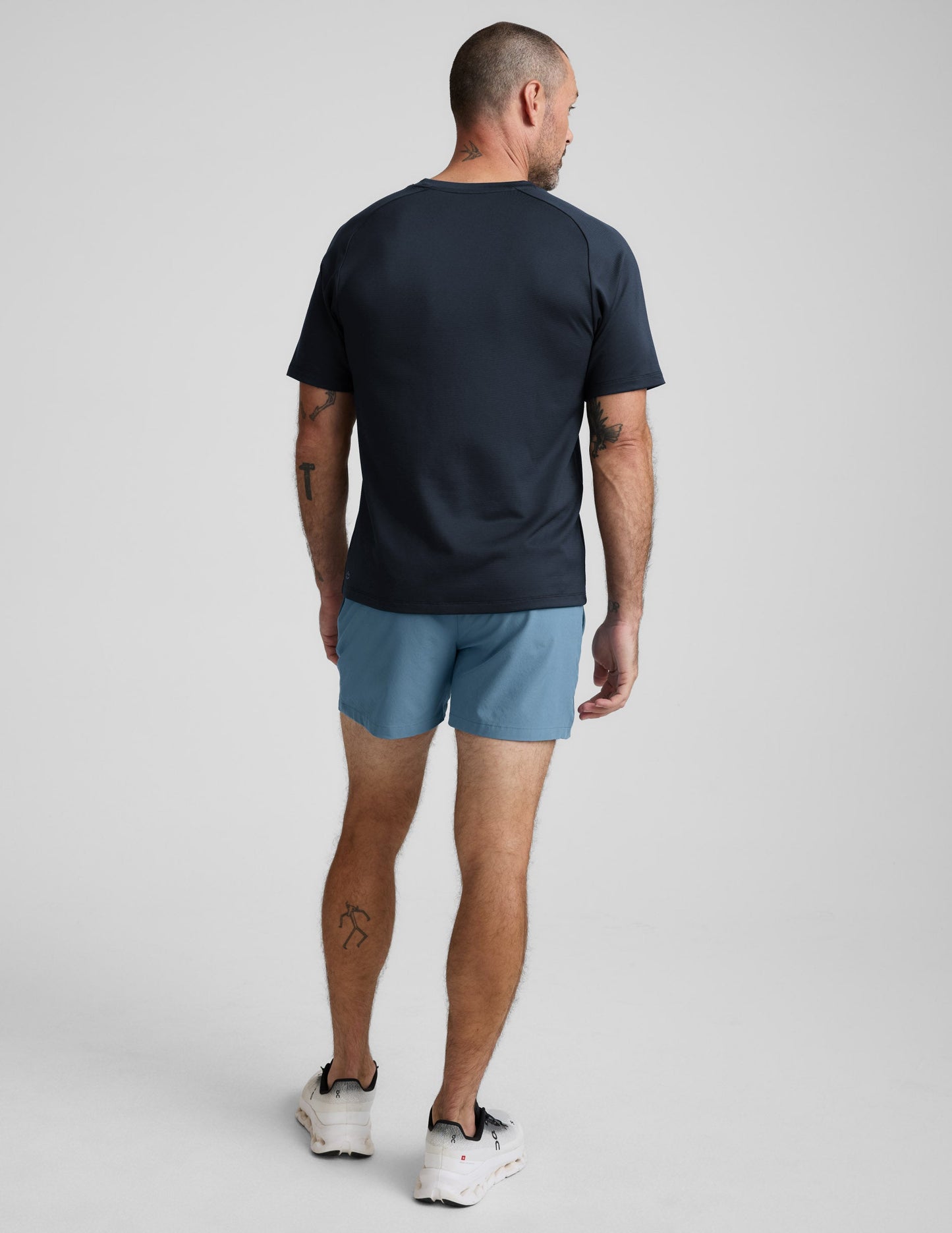 Rear view of a man wearing light blue Pivotal 2.0 Men's Lined Short 5" with a relaxed fit and mid-thigh length.