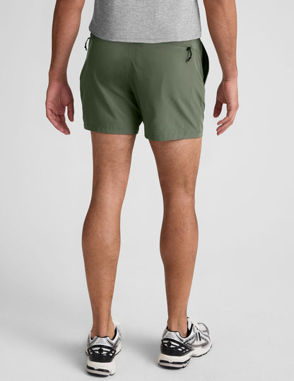 Back view of a man wearing Pivotal 2.0 Men's Lined Short 5" in olive green with an elastic waistband and zip back pocket.