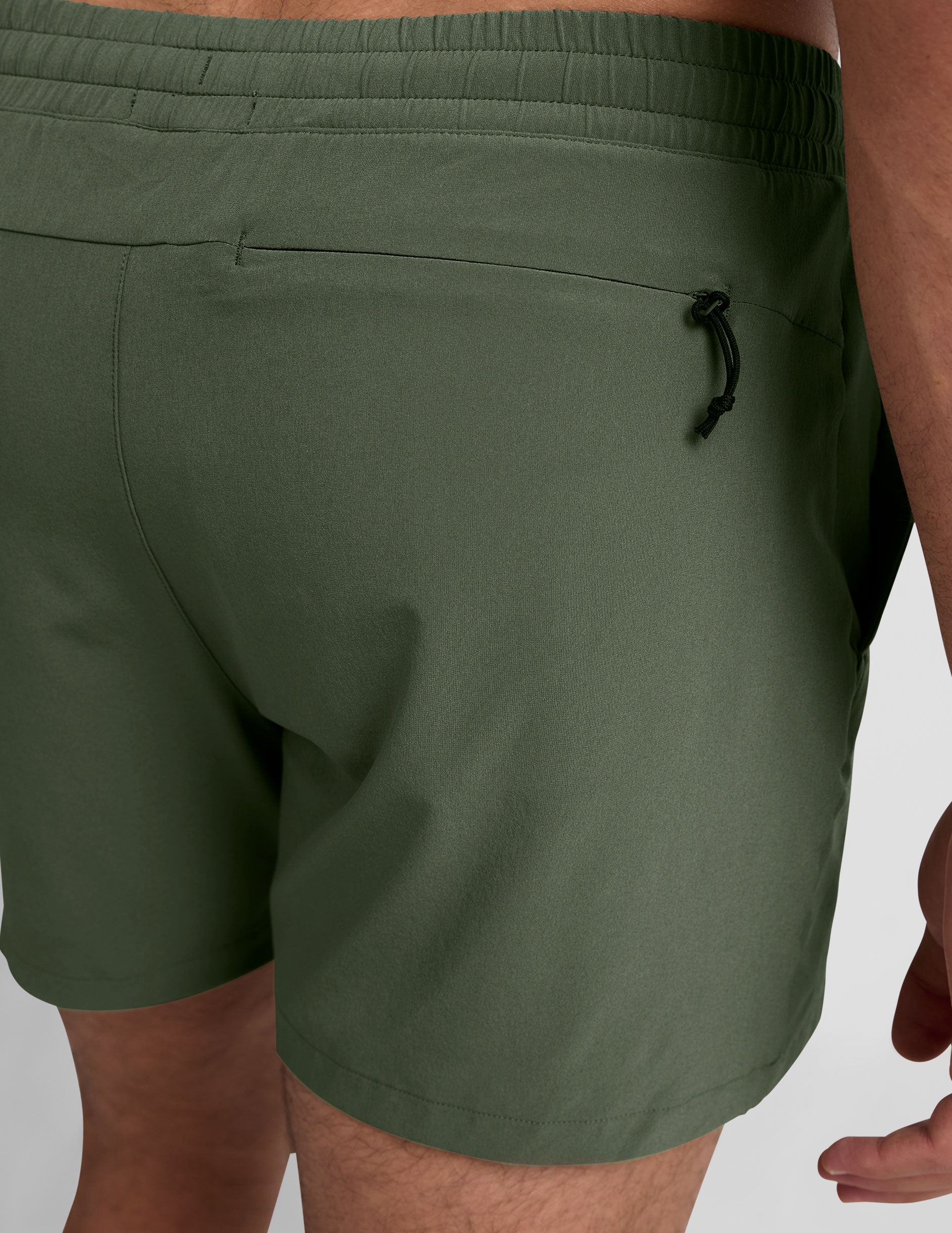 Back view of olive green Pivotal 2.0 Men's Lined Short 5" with elastic waistband and zippered back pocket.