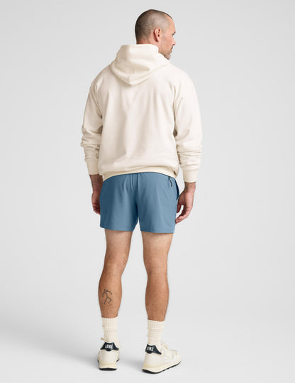 Back view of the blue Pivotal 2.0 Men's Short 5 inch, featuring a relaxed fit and mid-thigh length on a model.