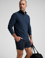 Man wearing a navy long-sleeve shirt and shorts on a white background.
