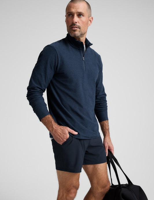 Man wearing a navy long-sleeve shirt and shorts on a white background.