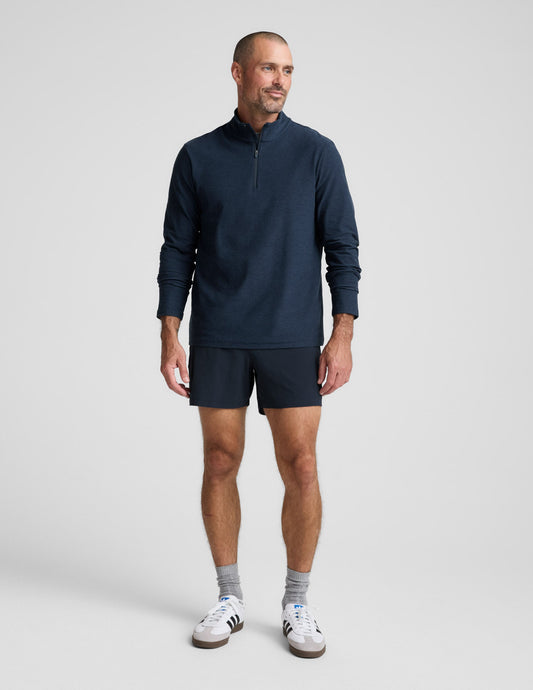 Man wearing a navy long-sleeve shirt and shorts on a white background.