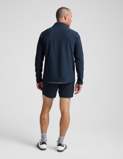 Man wearing a navy long-sleeve shirt and shorts on a white background.