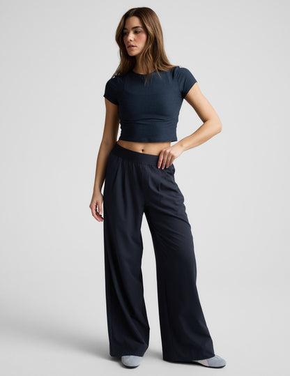 Model wears navy Elasticated Trouser Pant 29" featuring a wide-leg cut, pleated front, and mid-rise elastic waistband.