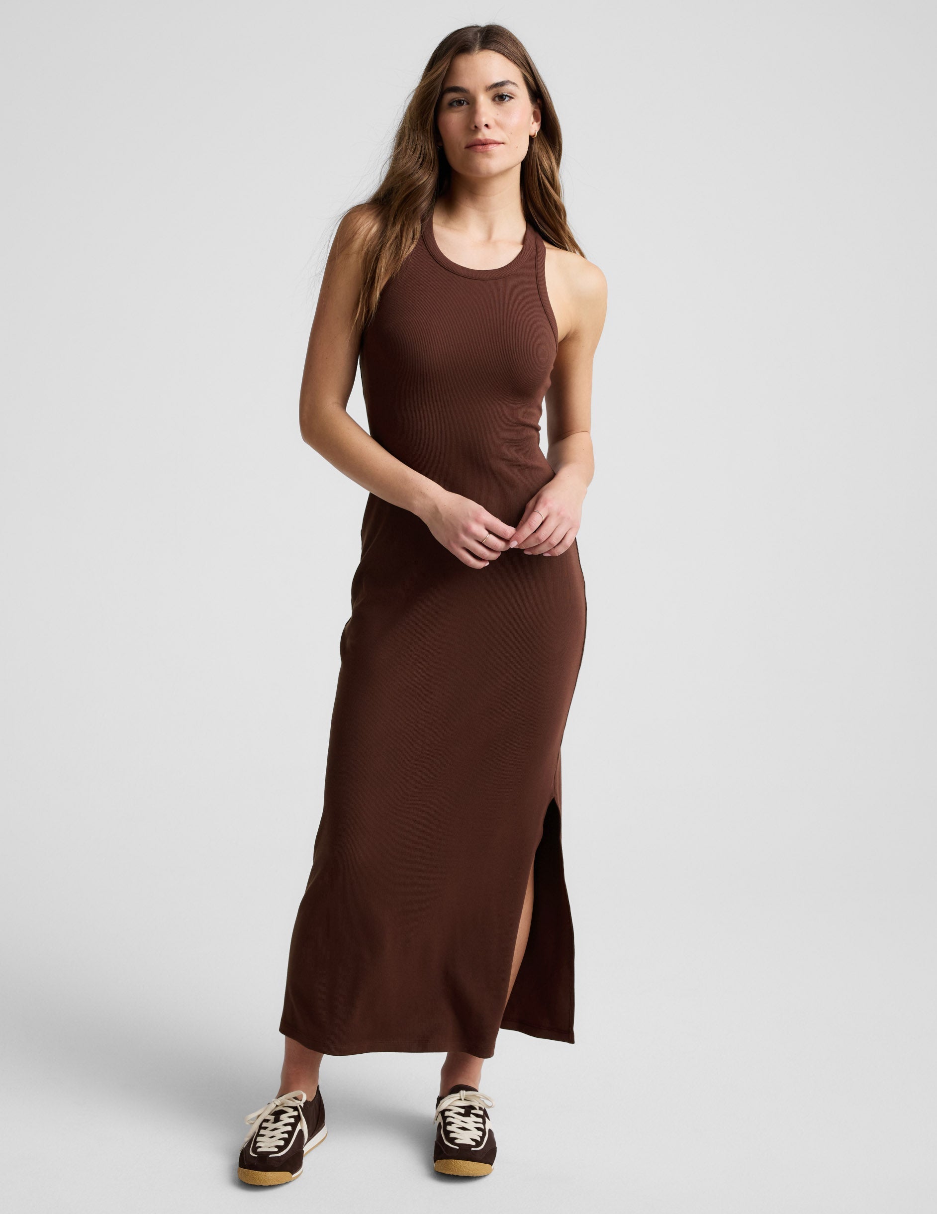 Woman wearing a ribbed brown maxi dress against a plain background.
