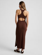 Woman wearing a ribbed brown maxi dress against a plain background.