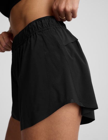 Black Solemate 2.5" Short on model featuring perforated side panels, a dolphin hem, and a gathered elastic waistband.