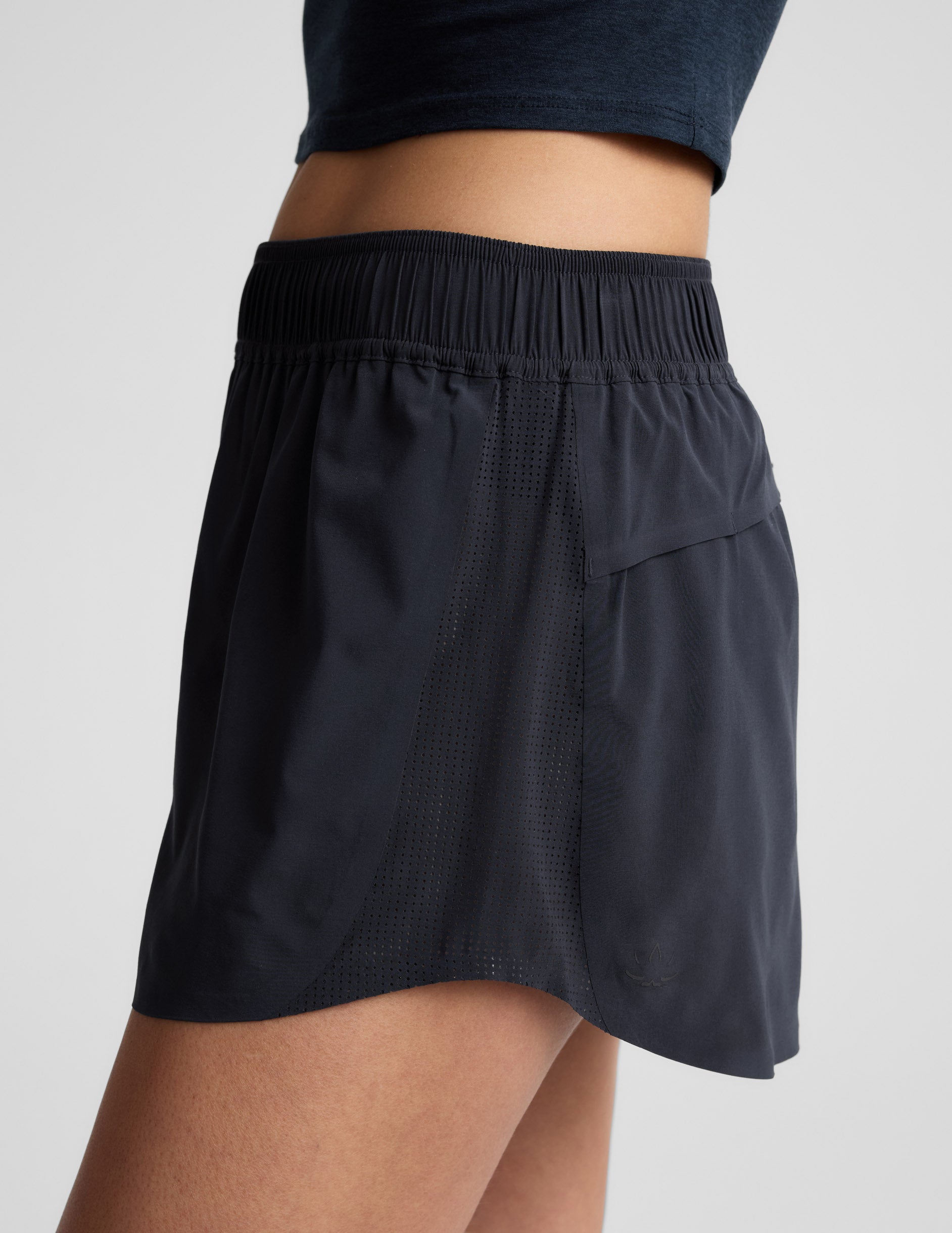 Side profile of navy Solemate 2.5" Short showing the gathered elastic waistband and perforated mesh side panels.