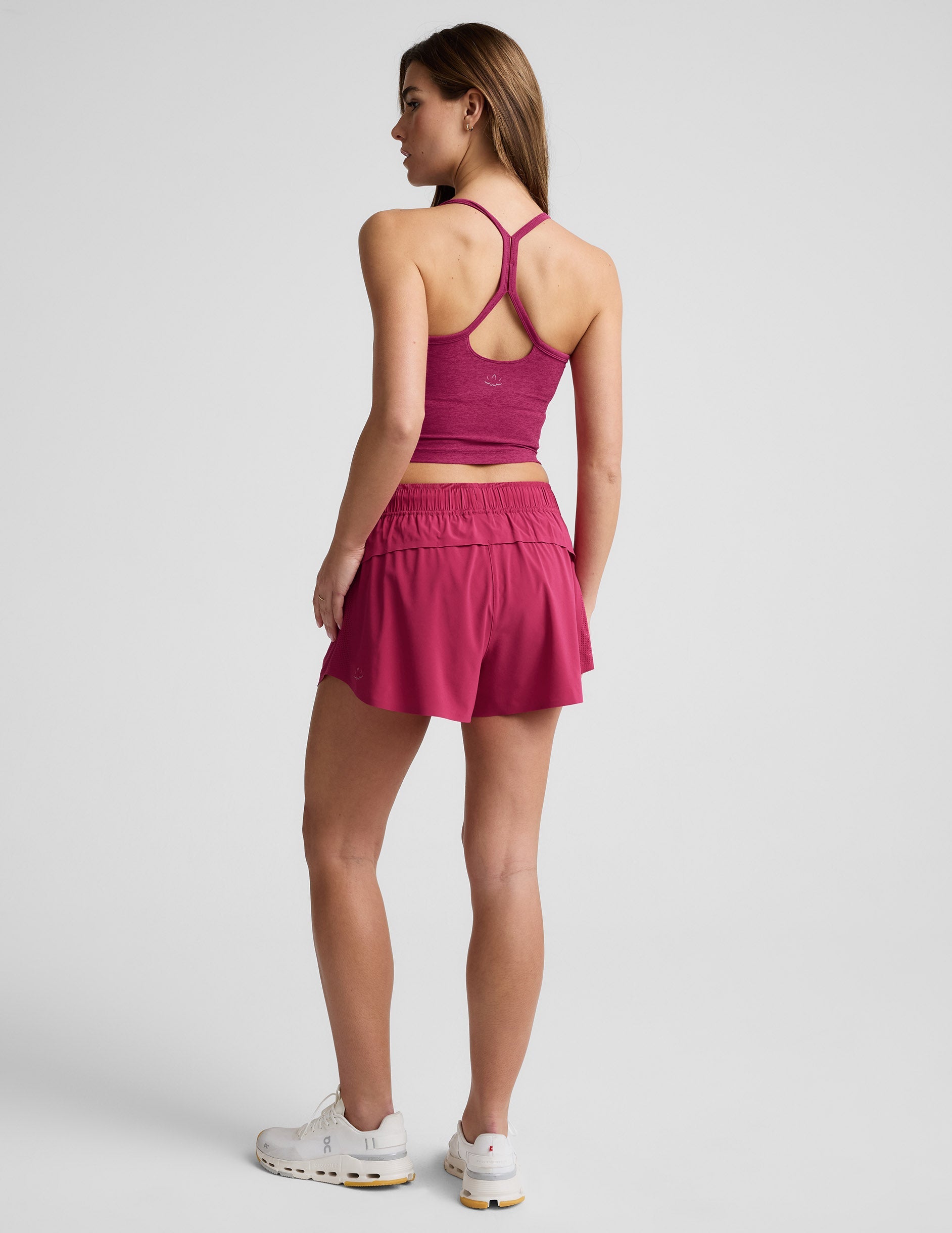 Back view of a woman wearing fuchsia Solemate 2.5" Shorts with a smocked waistband and matching tank top.