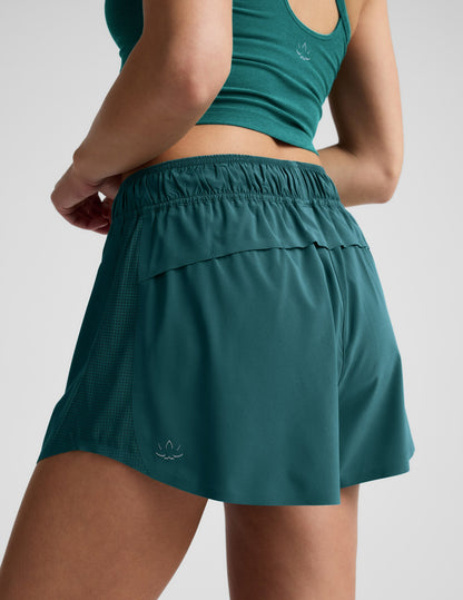 Woman wearing Teal Solemate 2.5" Short™ paired with a matching tank top, rear view showing a vented back panel.