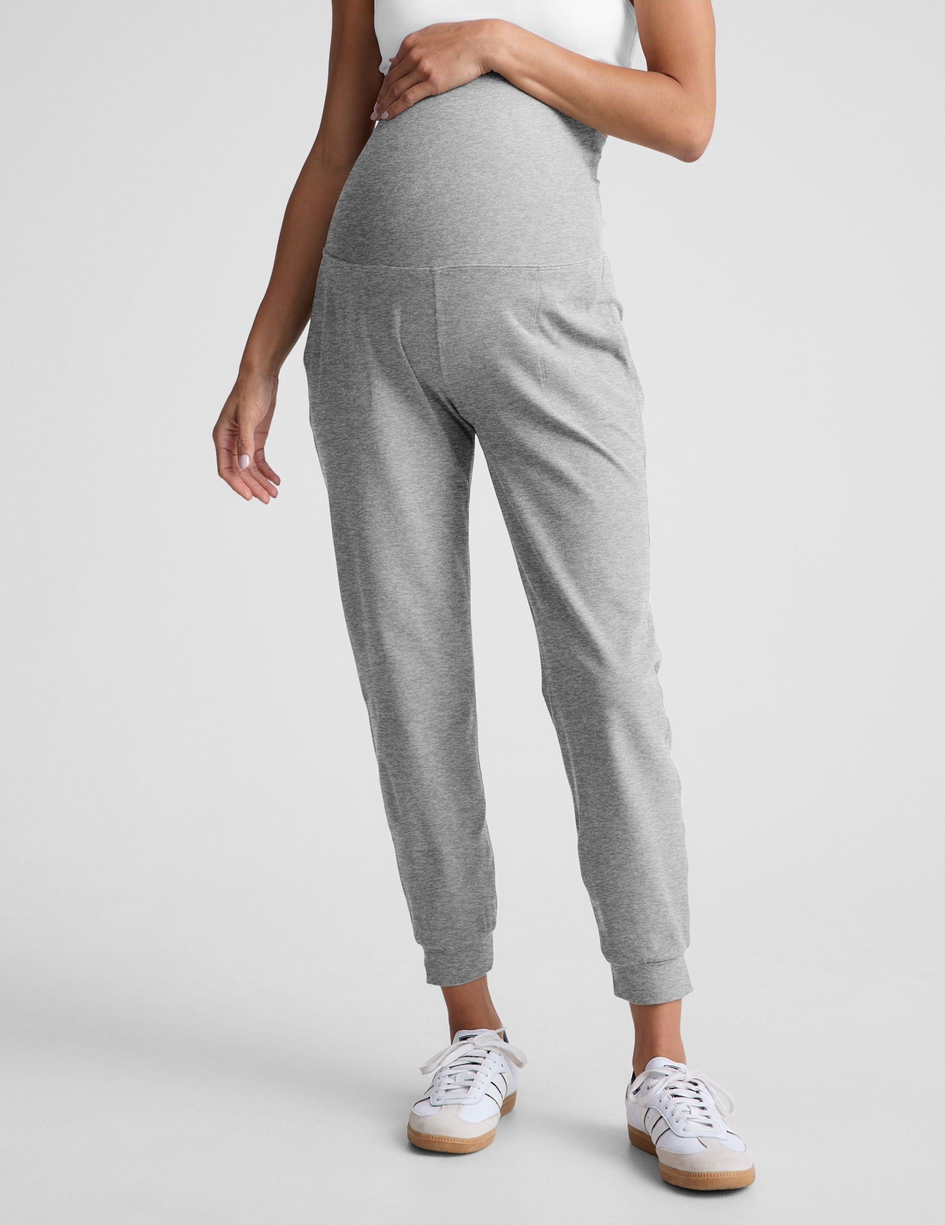 Woman wearing Gray Spacedye Beyond the Bump Maternity Midi Jogger with a white top and white sneakers.