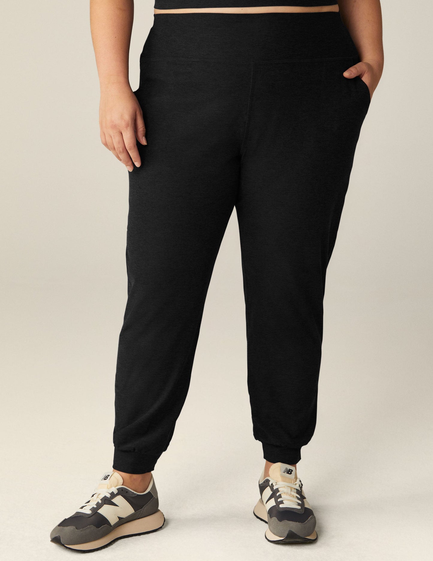 Person wearing the black Spacedye Midi Jogger featuring a wide waistband, slim tapered fit, and cuffed ankles.