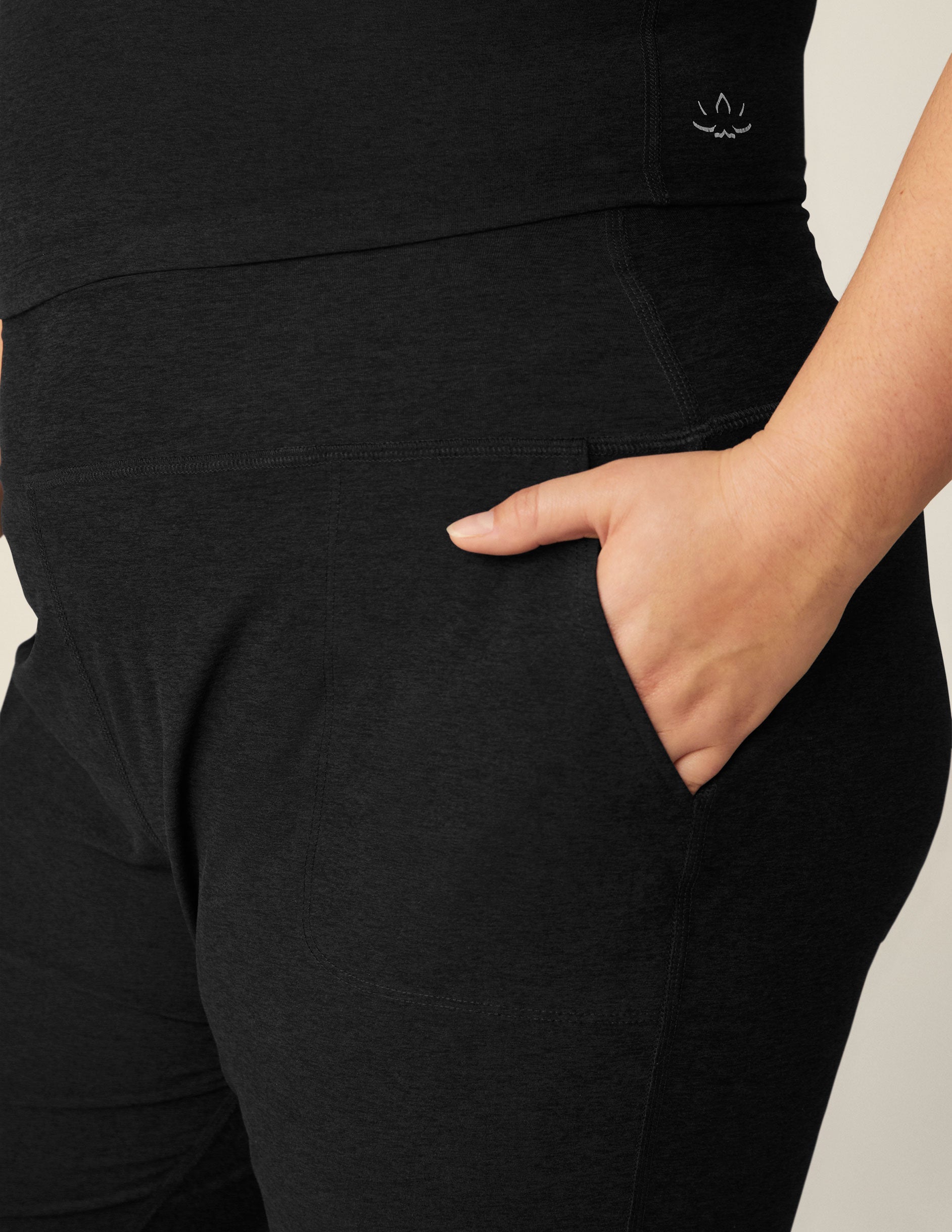 Close-up of Spacedye Midi Jogger in black marled fabric featuring a wide waistband and hand in a side slant pocket.