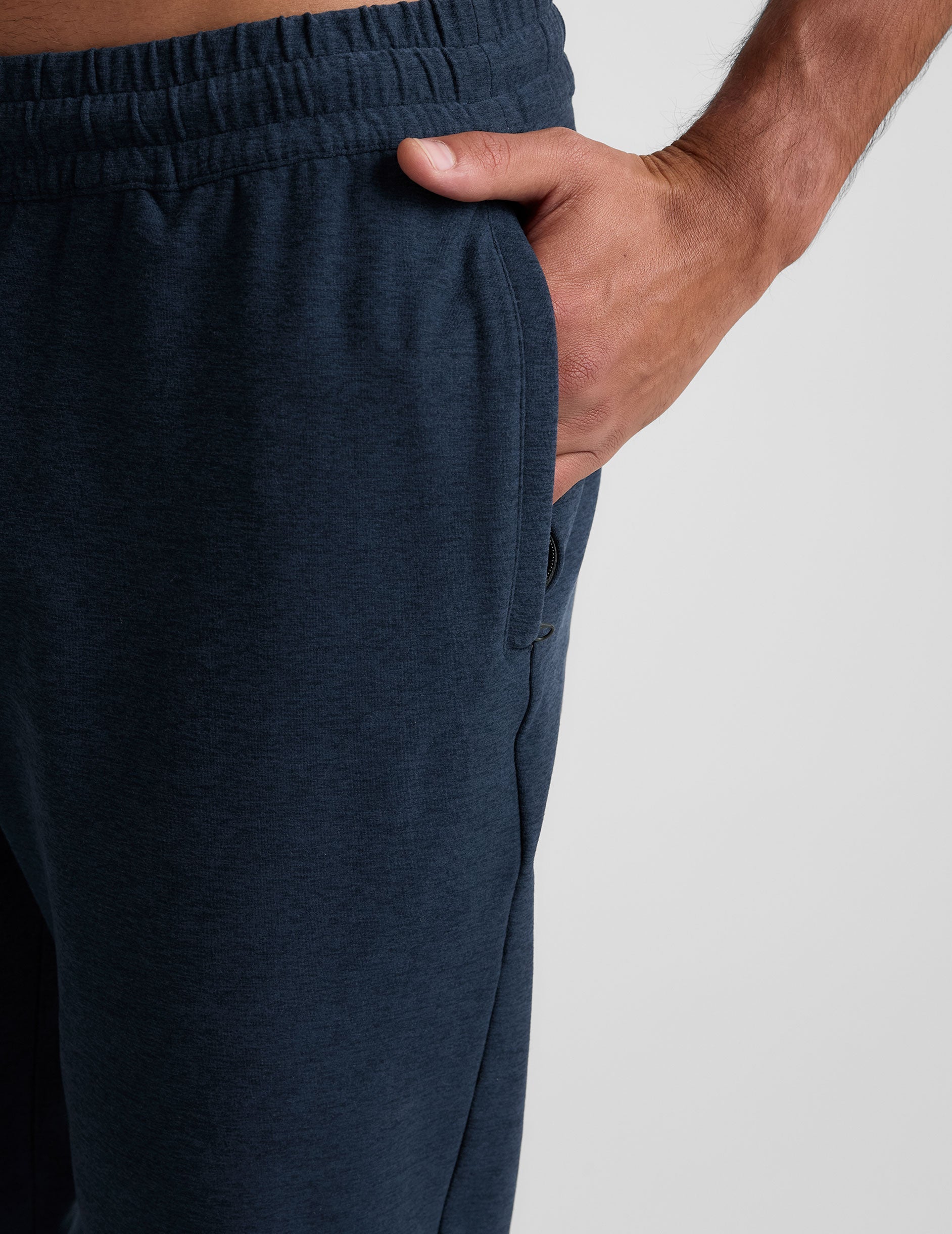 Close-up of the Spacedye Freefit Men's Zipper Pockets Jogger in navy marled fabric featuring a side zipper pocket and hand.