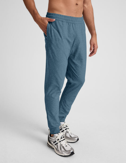 Man wearing Blue Spacedye Freefit Men's Jogger™ featuring zippered pockets, paired with white and silver sneakers.