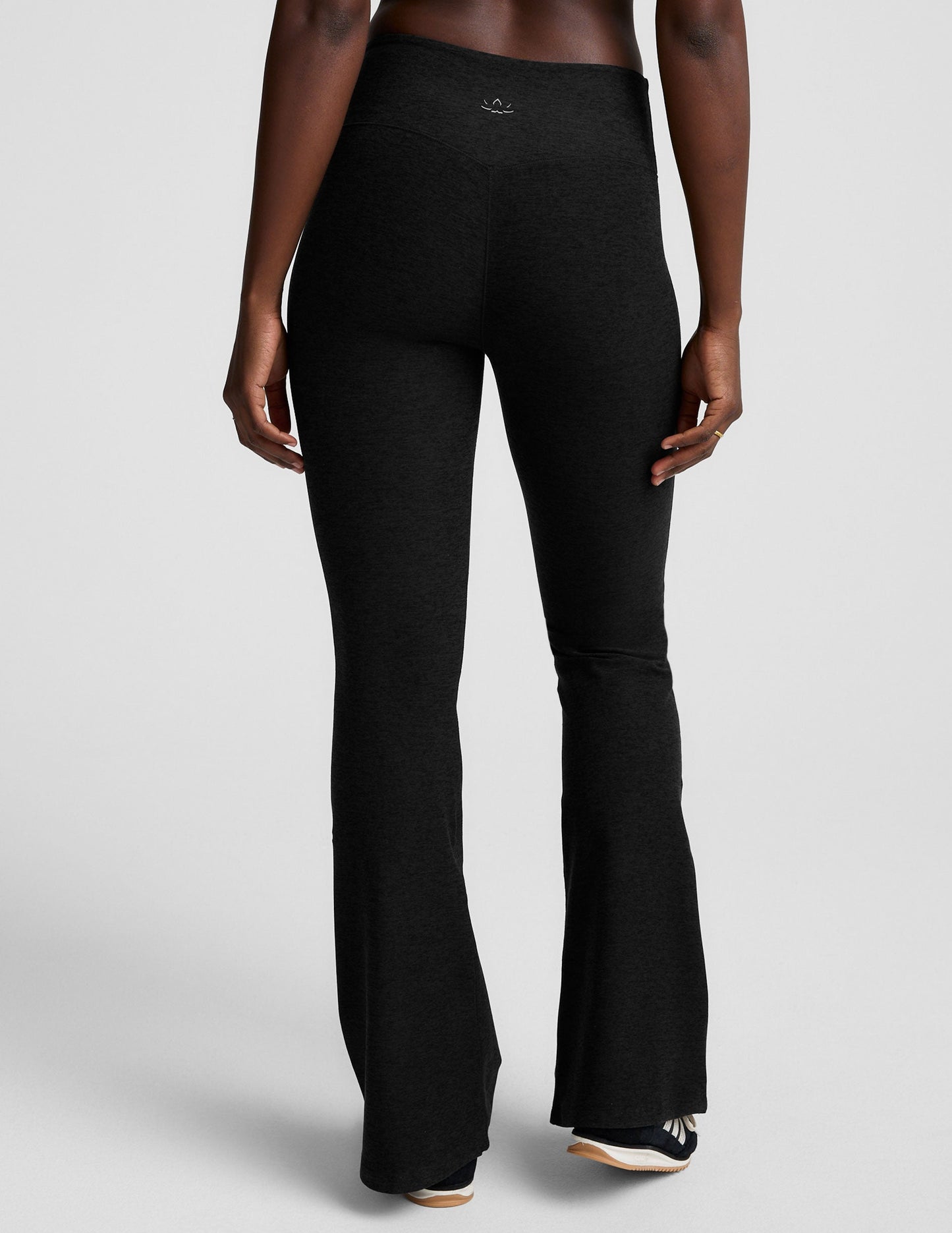 Rear view of the black Spacedye Mid-Rise Bootcut Pant, featuring a snug fit and flared legs on a neutral background.