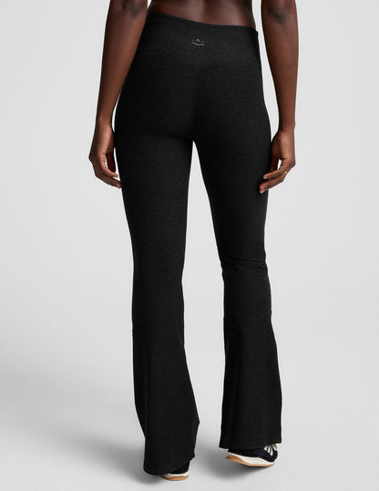 Rear view of the black Spacedye Mid-Rise Bootcut Pant, featuring a snug fit and flared legs on a neutral background.