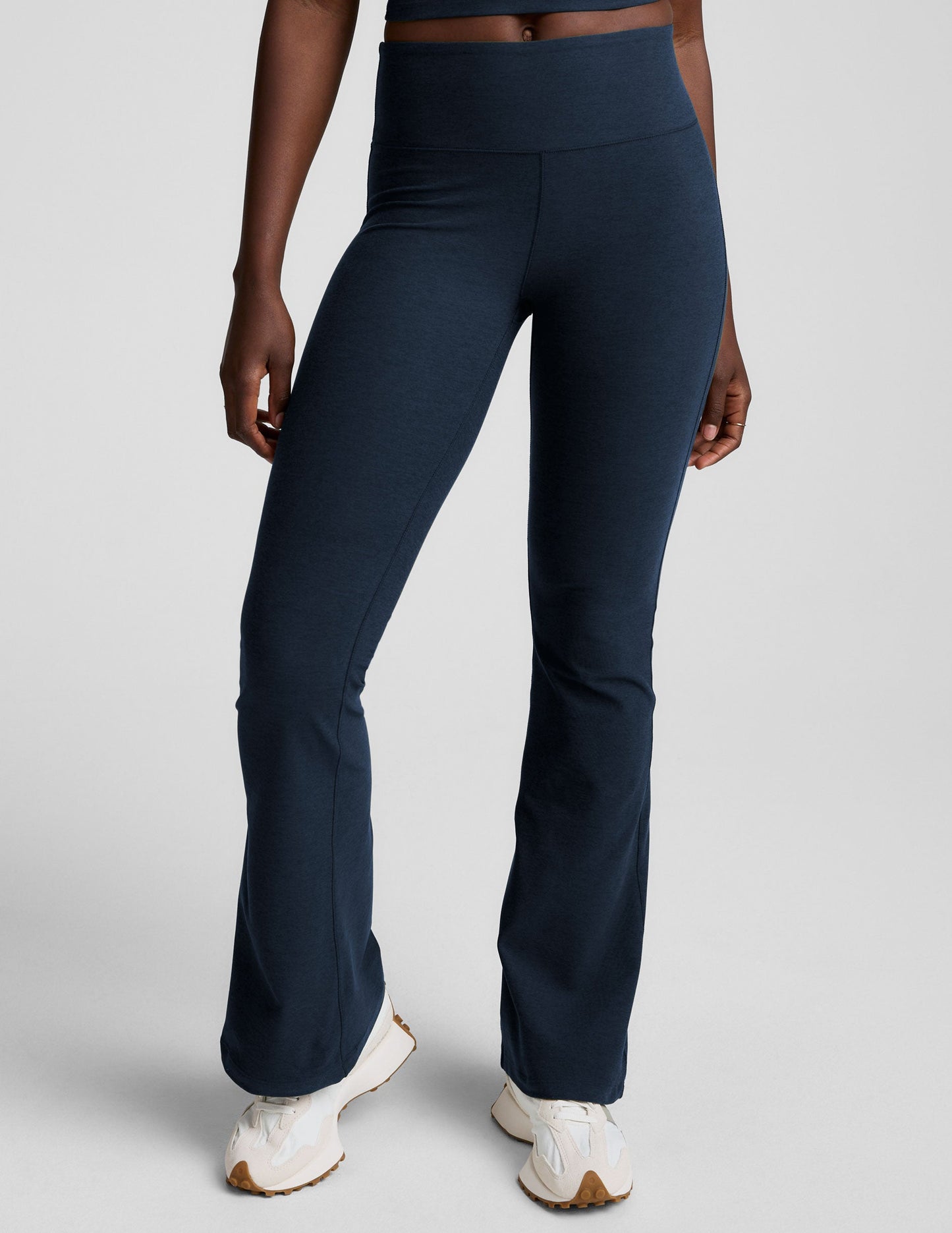 Navy Spacedye Mid-Rise Bootcut Pant featuring a wide waistband and flared leg, shown on a model with white sneakers.