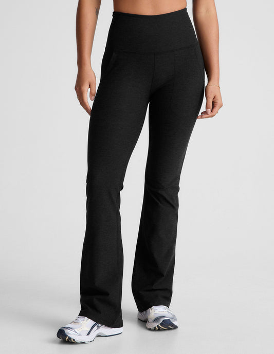 Model wearing black Spacedye High Waisted Practice Pocket Bootcut Pant with a wide waistband, hip pockets, and flared hem.