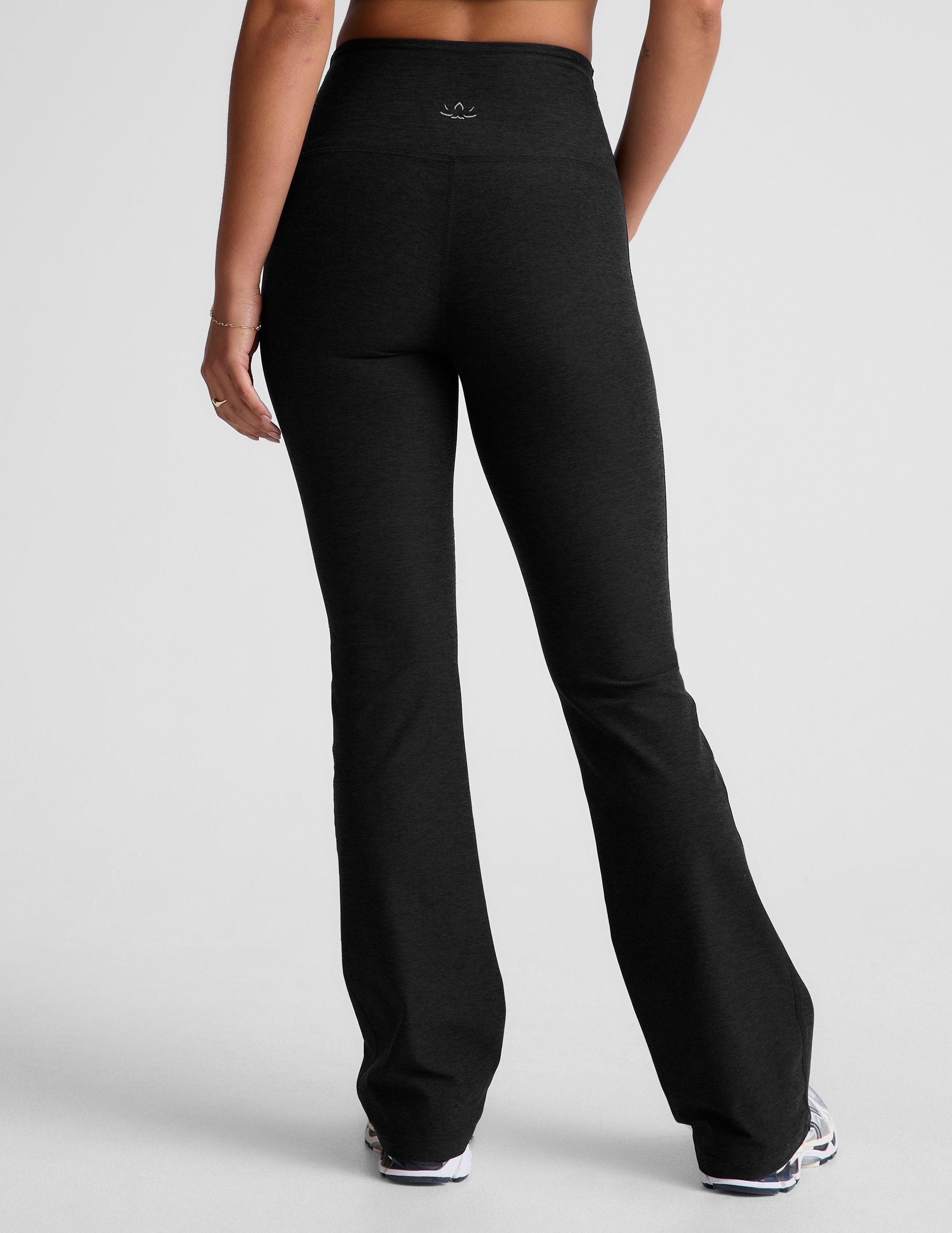 Rear view of the black Spacedye High Waisted Practice Pocket Bootcut Pant with flared legs and a high, wide waistband.