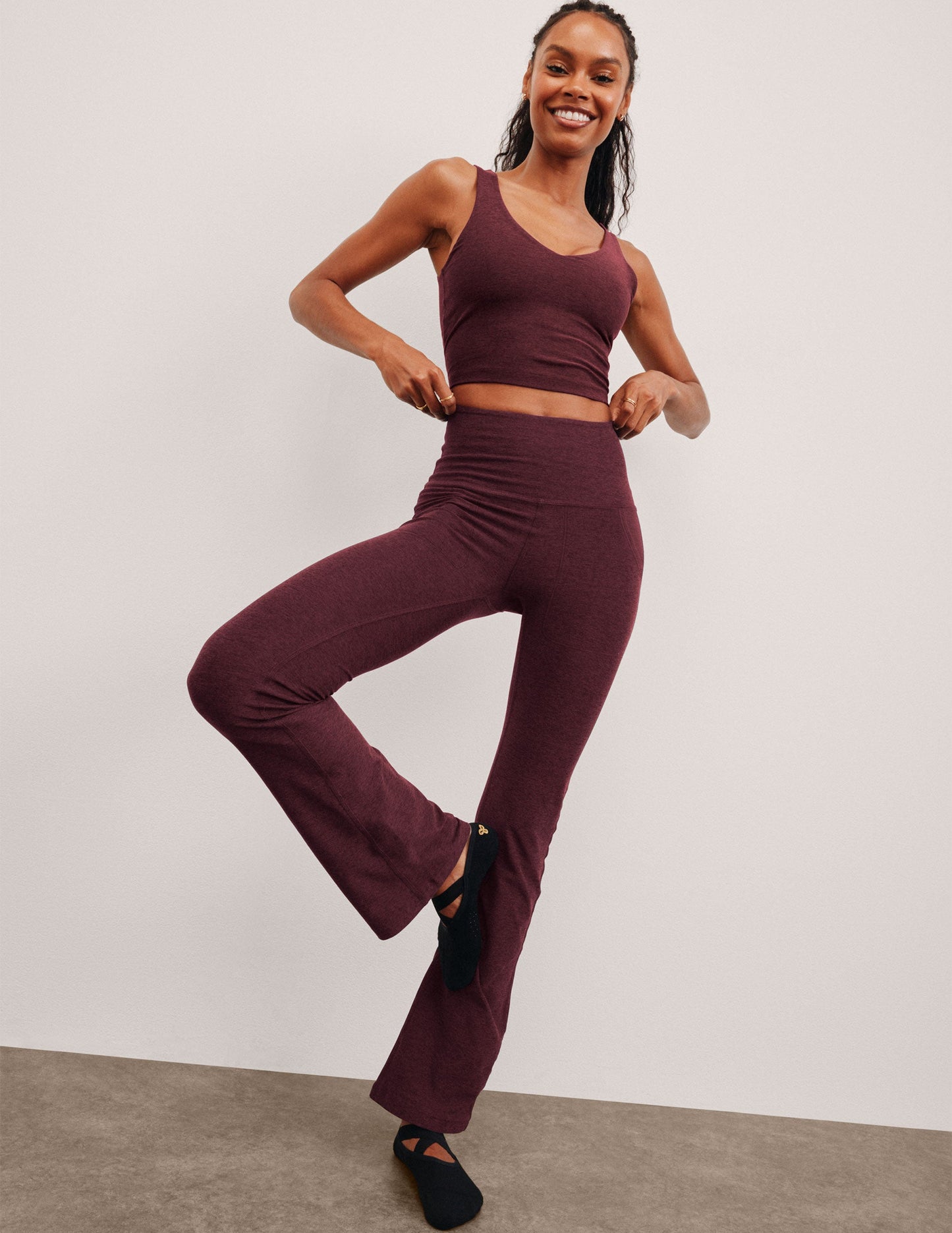 Woman wearing Maroon Spacedye High Waisted Practice Pocket Bootcut Pant™ with a matching crop tank in a tree yoga pose.