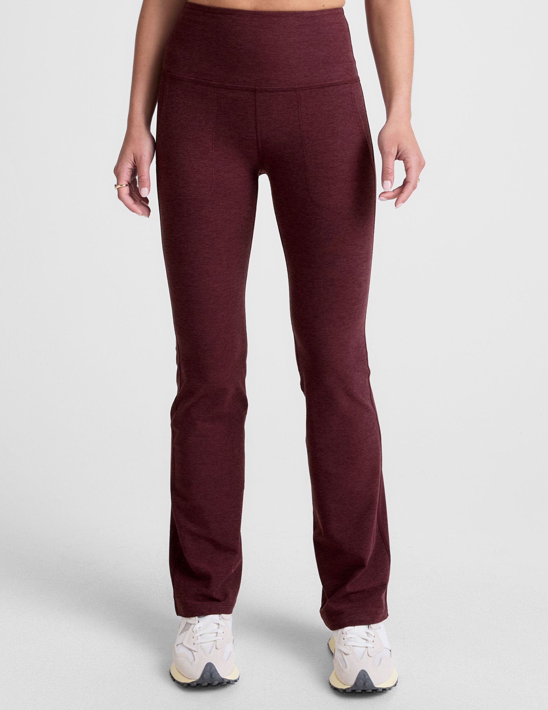Woman wearing Maroon Spacedye High Waisted Practice Pocket Bootcut Pant™ with front pockets and white sneakers.