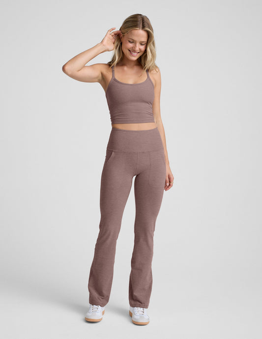 Smiling woman wearing brown Spacedye High Waisted Practice Pocket Bootcut Pant 31" featuring front pockets and flared leg.