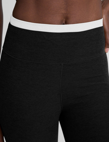 Close-up of Spacedye Layered Bootcut Pant in black with a high-waisted, double-layer white contrast waistband on a model.