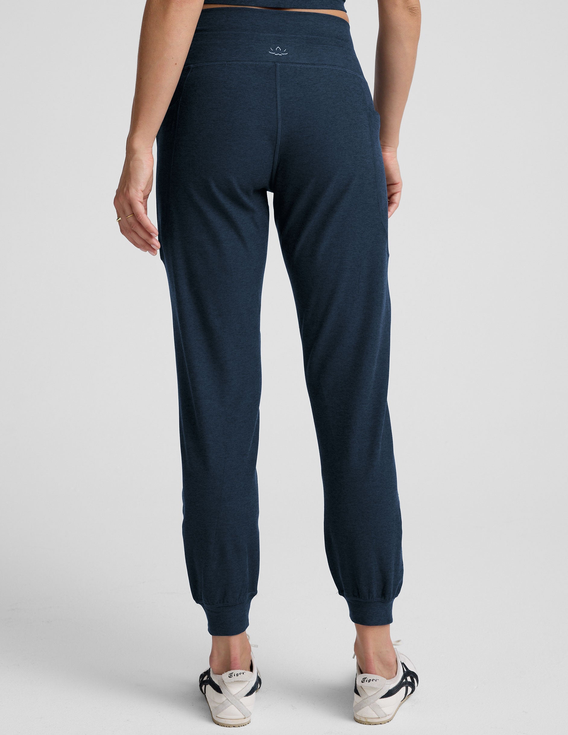 Rear view of a person wearing navy Spacedye Go Pocket Joggers with a high waistband, side pockets, and cuffed ankles.