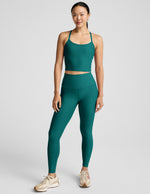 Woman wearing a green athletic outfit on a white background.