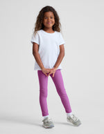 Girl wearing Purple Spacedye™ Toddler Legging paired with a white t-shirt and grey sneakers.