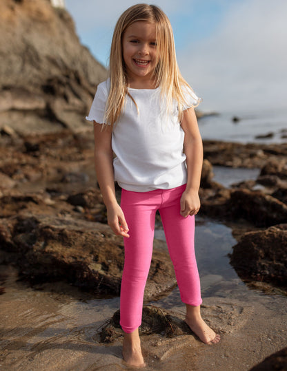 Girl wearing Pink Spacedye™ Toddler Legging with a high waistband paired with a white t-shirt.